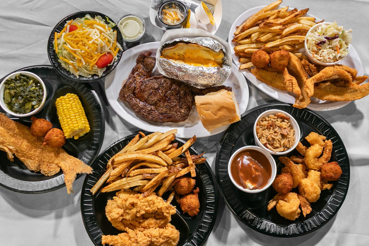 Plates of catfish, shrimp and sides on a table